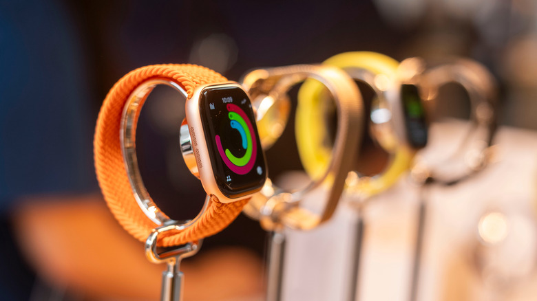 A row of various Apple Watch models on display in a store showroom.