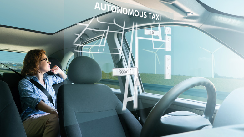 A person sitting in a vehicle appearing relaxed, illustrating the potential for over-reliance on automation.