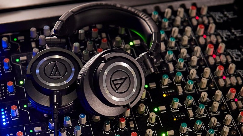 Audio-Technica ATH-M50x headphones placed on a professional audio mixing console.