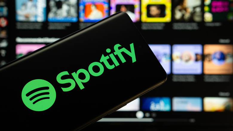 The Spotify logo glowing on a smartphone screen.