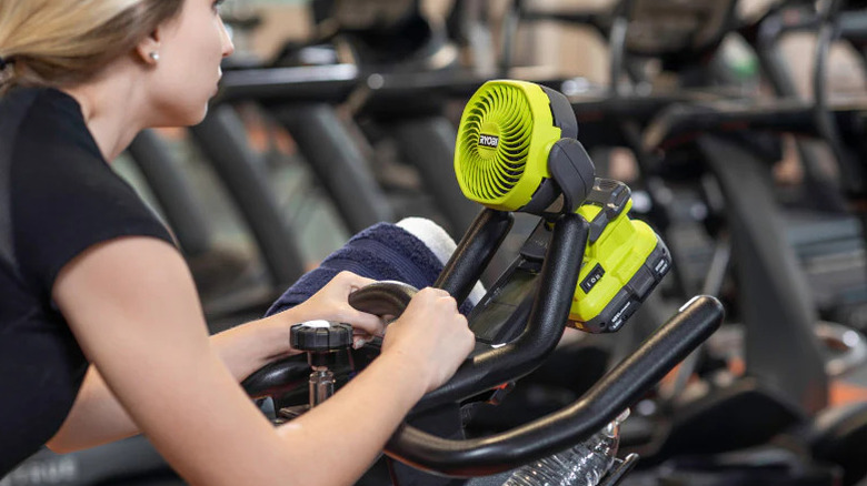 A Ryobi 18V 4-inch clamp fan secured to an exercise bike.