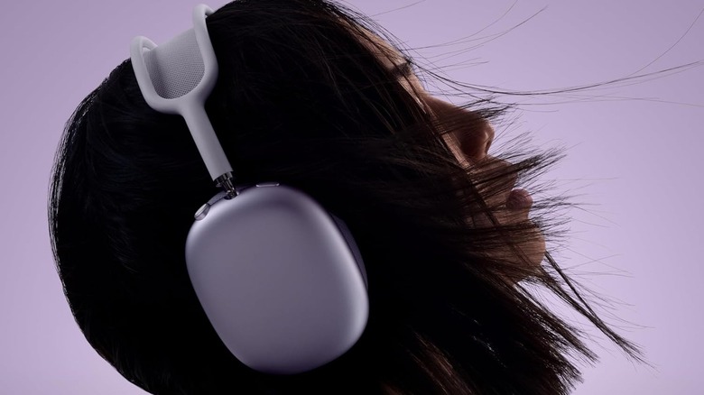 A woman wearing Apple AirPods Max 2 headphones in a lifestyle setting.
