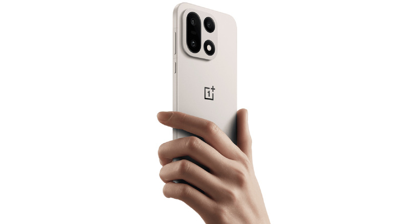 A hand holding the OnePlus 15 smartphone.