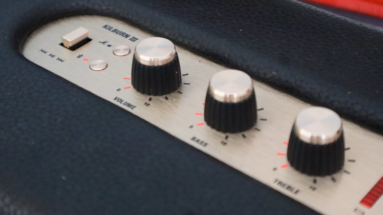 Close-up of the brass analog control knobs and power switch on top of the Marshall Kilburn 3.