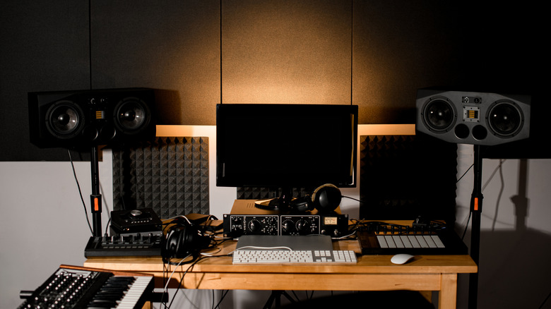 A laptop setup with external speakers and musical equipment connected via various interfaces.