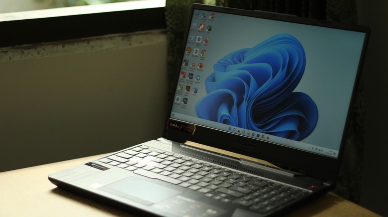 A laptop on a desk showing the Windows 11 desktop interface.