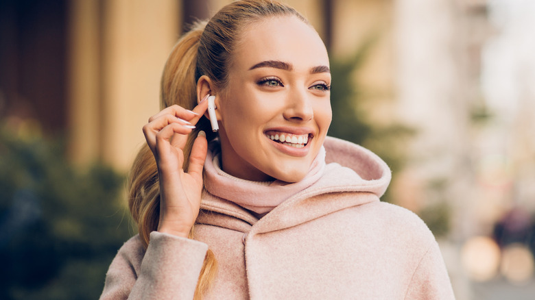 A person wearing AirPods while working in a public space.